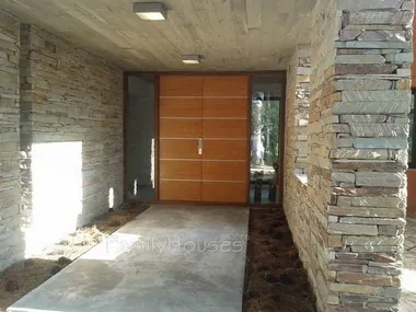 Acceso principal con piedra local y madera